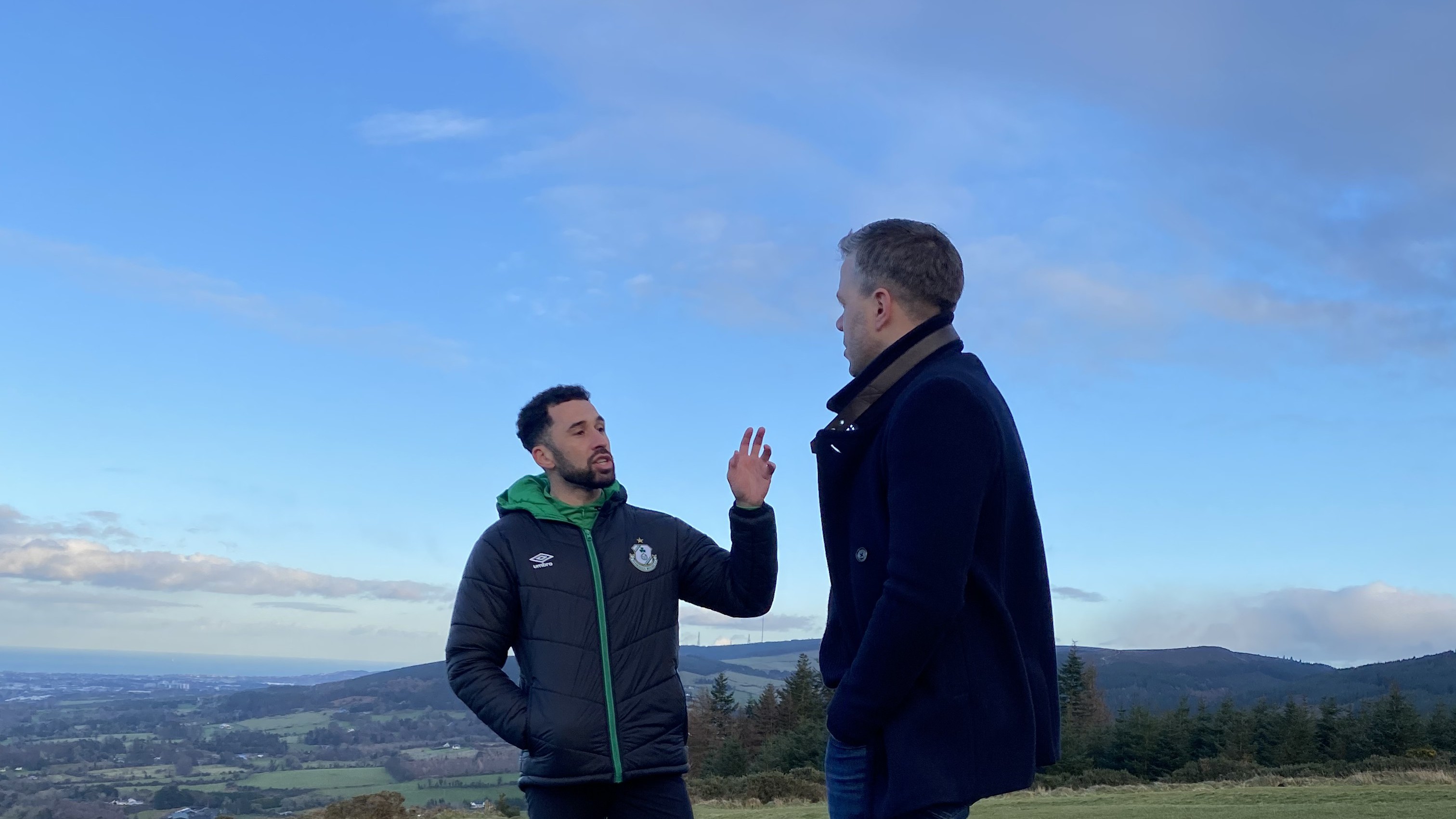 Two men in conversation on a hillside during filming of the Shamrock Rovers Clear the Head documentary